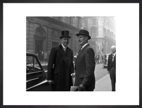 Three formally dressed men on a street flanked by high buildings. c.1955