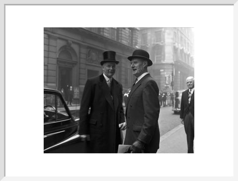 Three formally dressed men on a street flanked by high buildings. c.1955