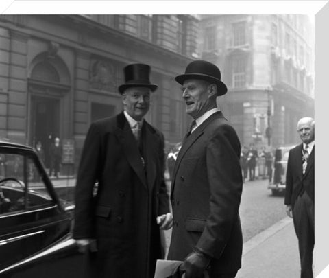 Three formally dressed men on a street flanked by high buildings. c.1955