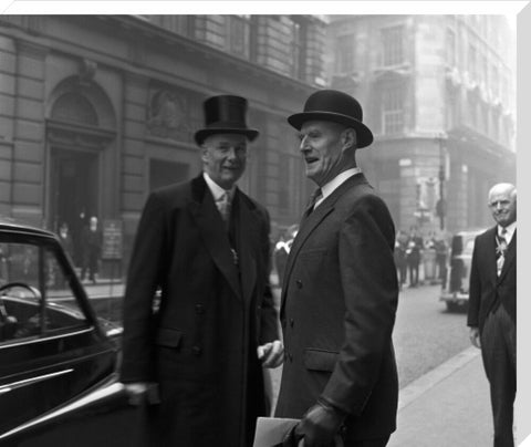 Three formally dressed men on a street flanked by high buildings. c.1955