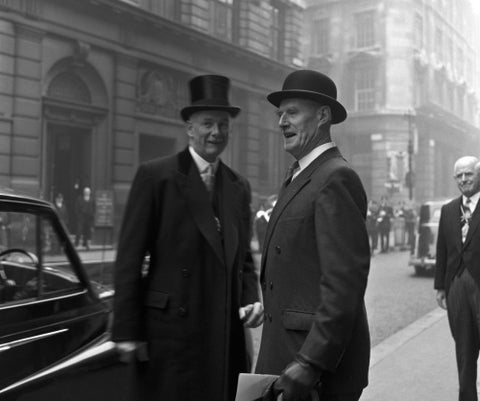 Three formally dressed men on a street flanked by high buildings. c.1955