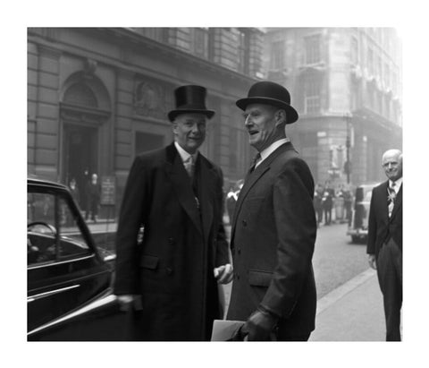 Three formally dressed men on a street flanked by high buildings. c.1955