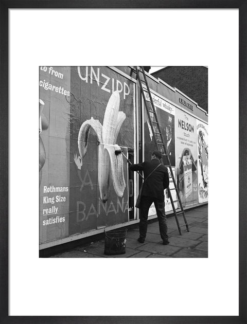 Man pastes up a billboard advertisement. c.1955
