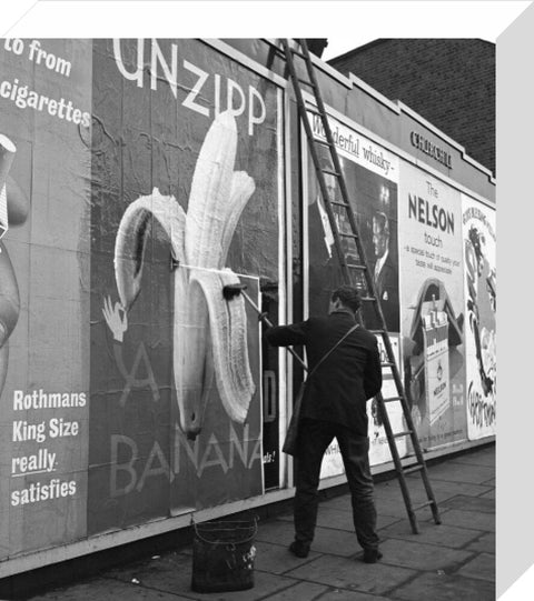 Man pastes up a billboard advertisement. c.1955