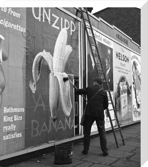 Man pastes up a billboard advertisement. c.1955