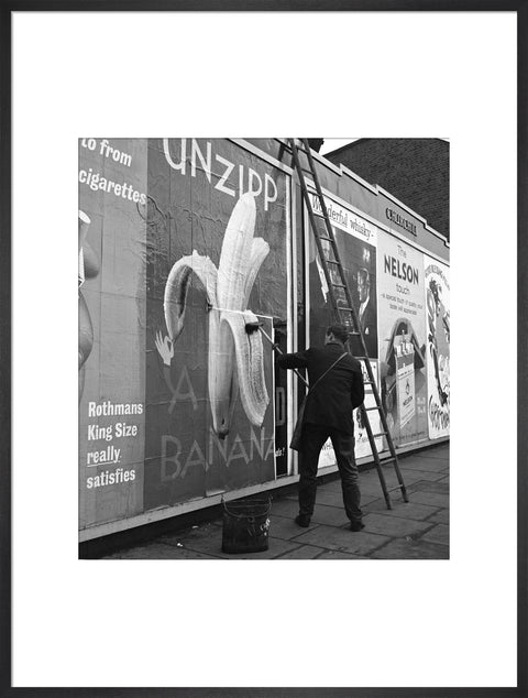 Man pastes up a billboard advertisement. c.1955