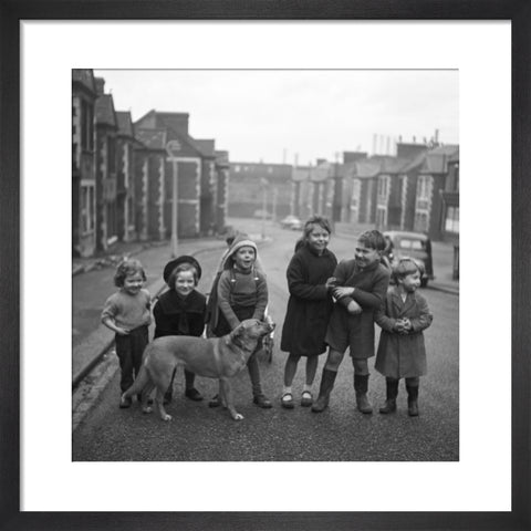 Children gathered in street with dog. c.1955