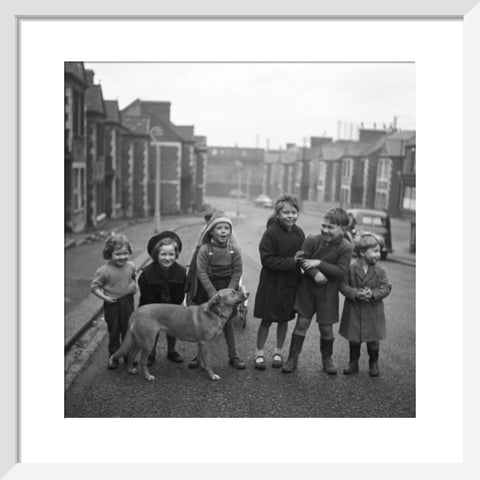 Children gathered in street with dog. c.1955