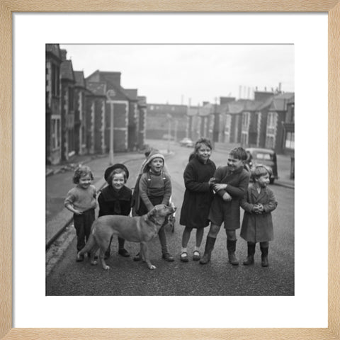 Children gathered in street with dog. c.1955