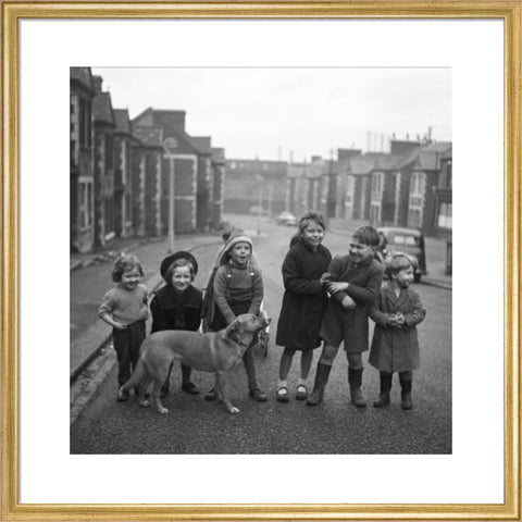 Children gathered in street with dog. c.1955