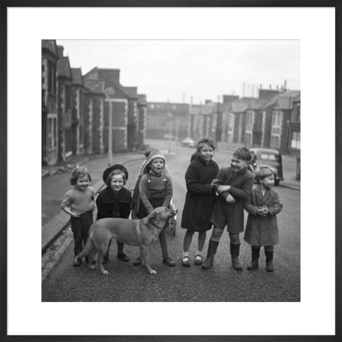 Children gathered in street with dog. c.1955