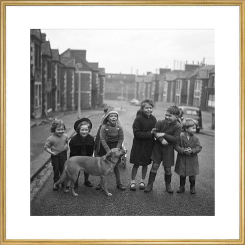 Children gathered in street with dog. c.1955