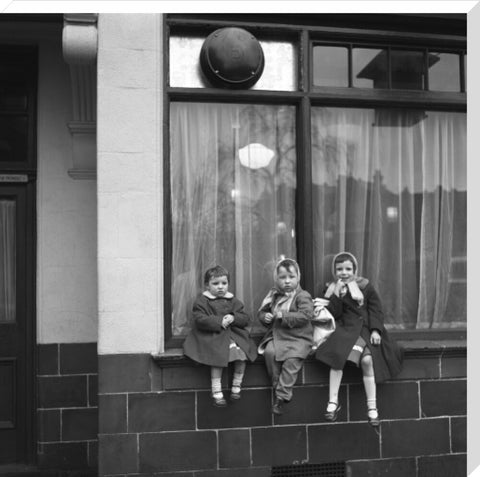 Three children perched on the windowsill of a pub. c.1955