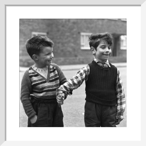 Two boys hold hands in street. c.1955