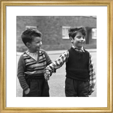 Two boys hold hands in street. c.1955