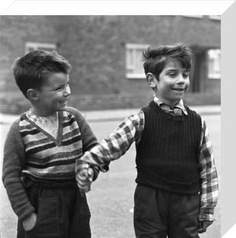 Two boys hold hands in street. c.1955