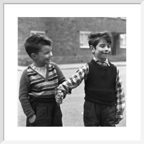 Two boys hold hands in street. c.1955