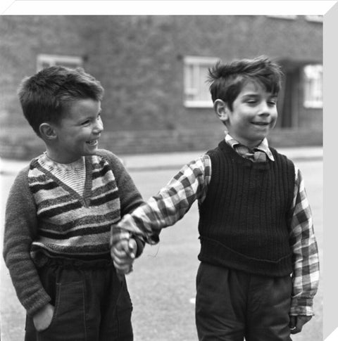 Two boys hold hands in street. c.1955