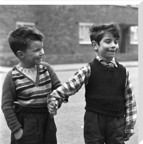 Two boys hold hands in street. c.1955