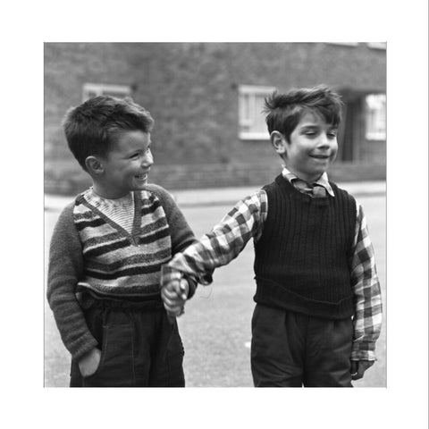 Two boys hold hands in street. c.1955