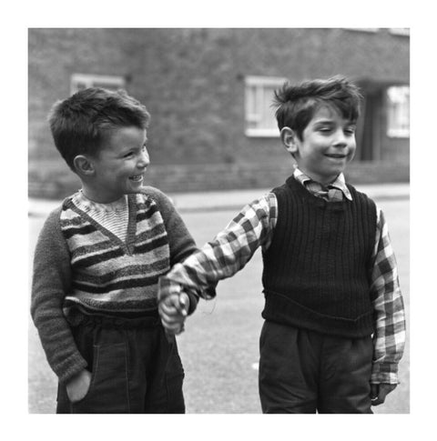 Two boys hold hands in street. c.1955