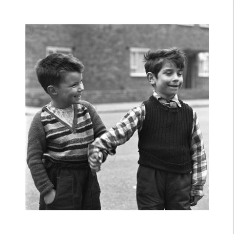 Two boys hold hands in street. c.1955